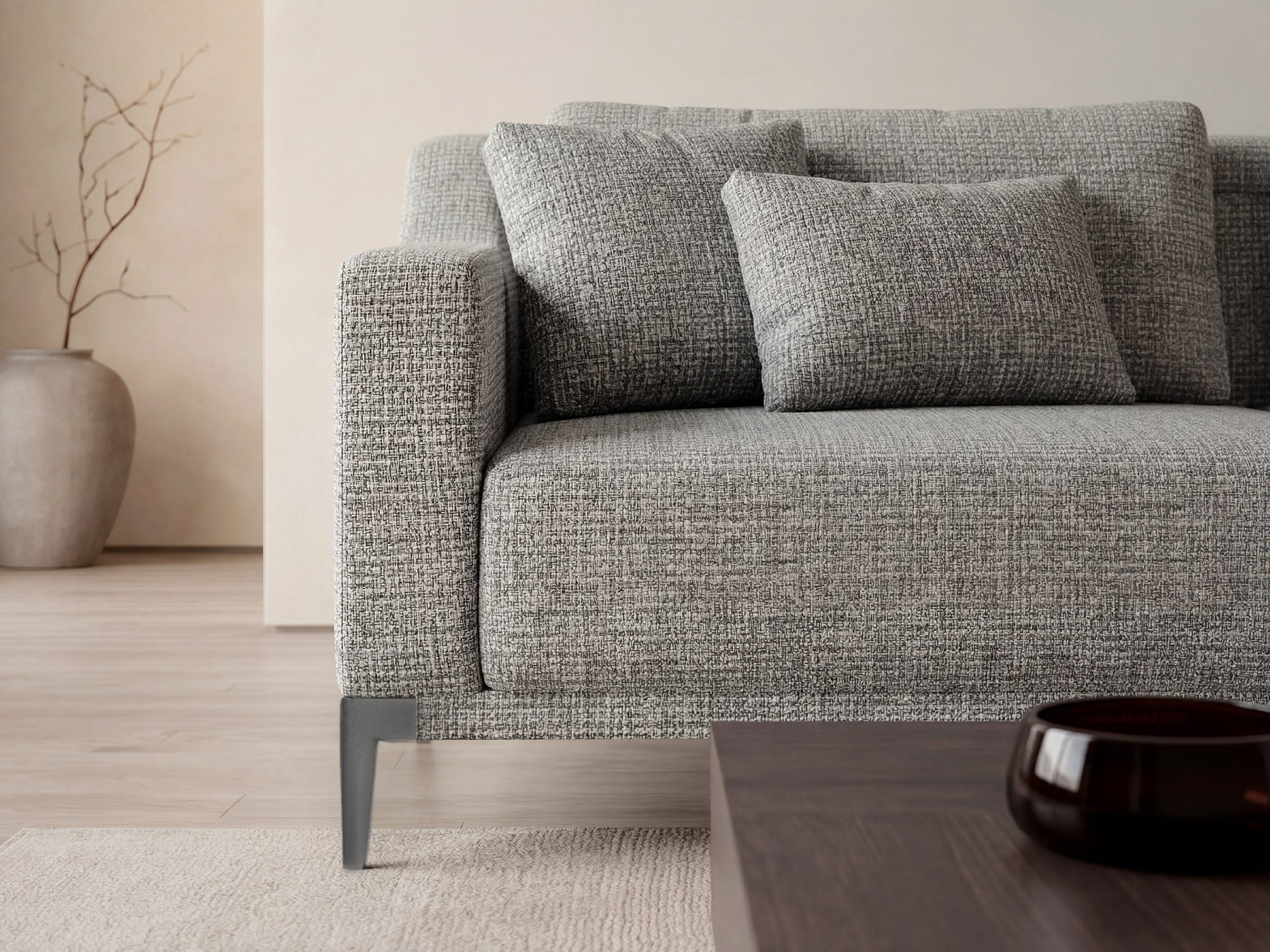 Gray textured sofa in a minimalistic living room setting with a neutral color palette.