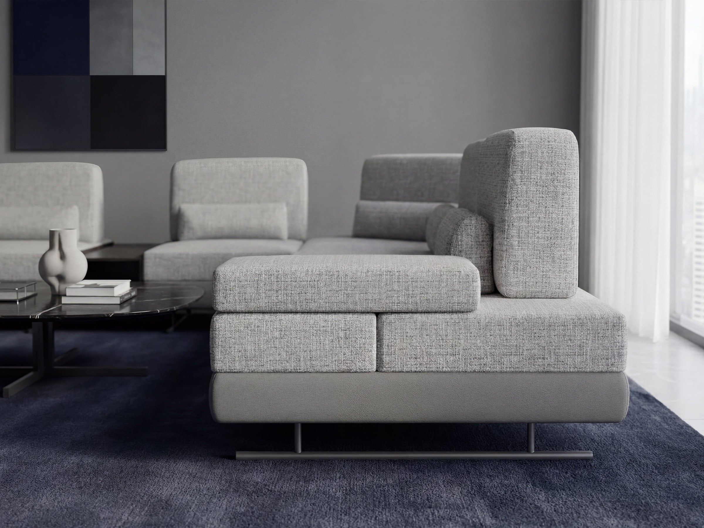 Gray sectional sofa in a modern living room with a abstract painting on the wall.