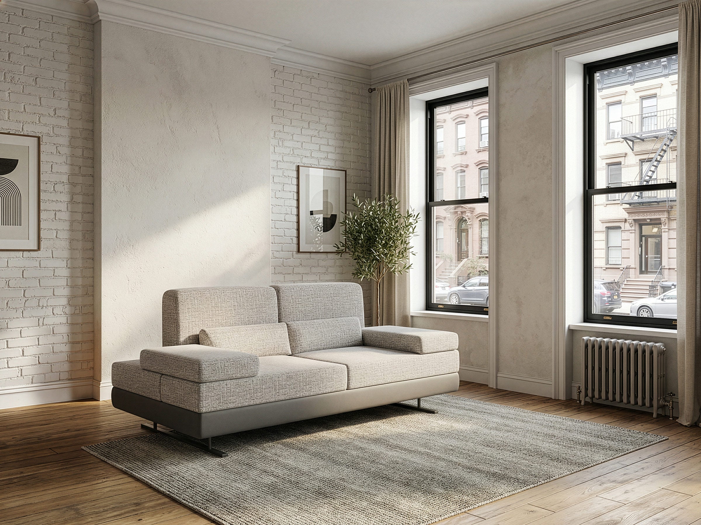 Modern living room with a gray sofa, large windows, and a brick wall.