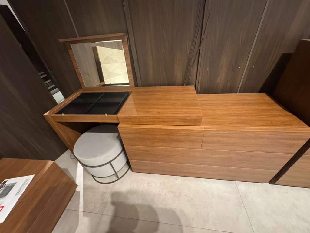 Wooden vanity with mirror and stool in a room with wooden walls.