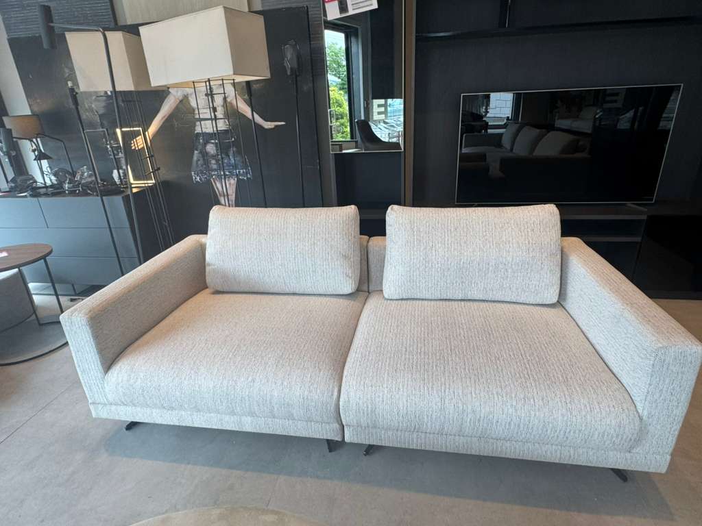 Beige sofa in a room with a television and decor elements.