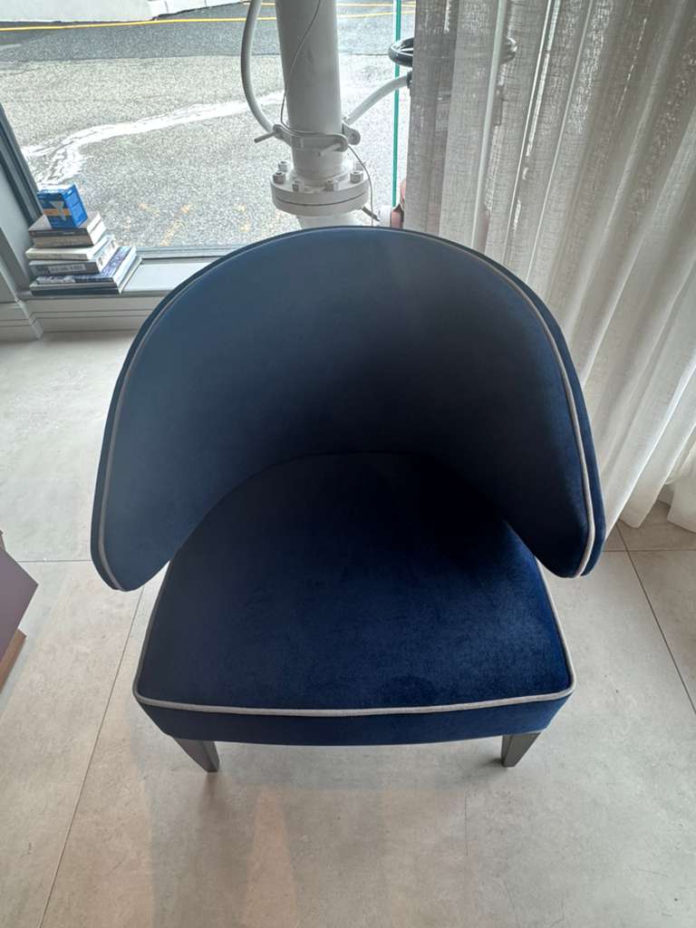 Blue chair with white trim on a tiled floor