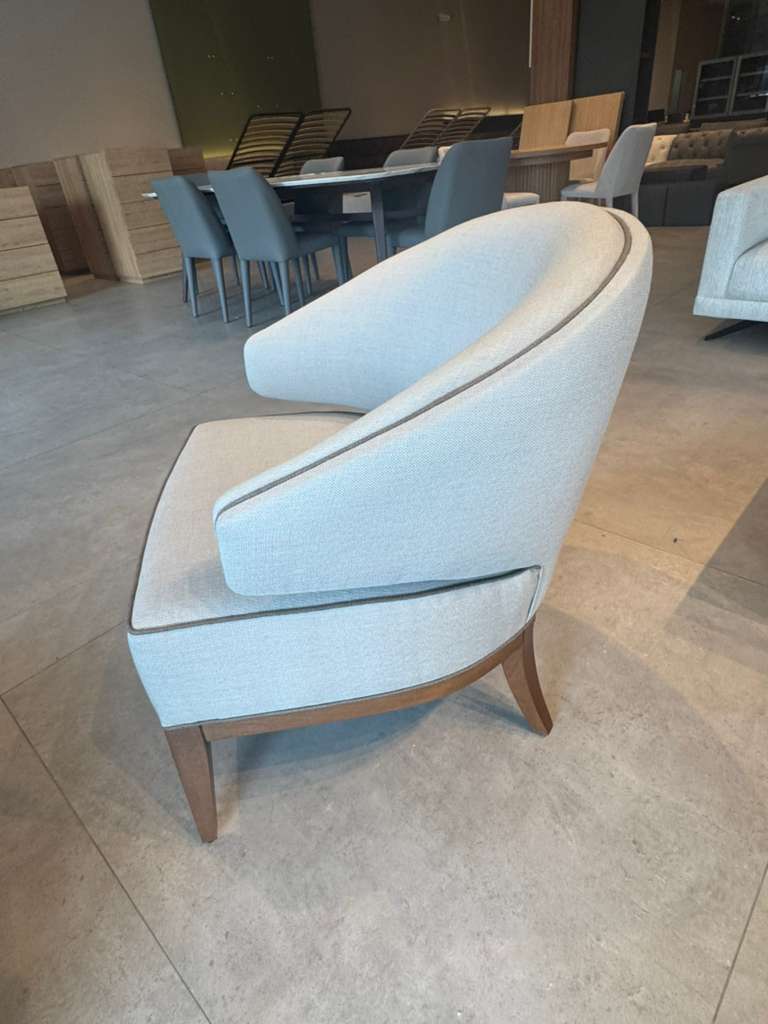 Light blue armchair in a room with tables and chairs