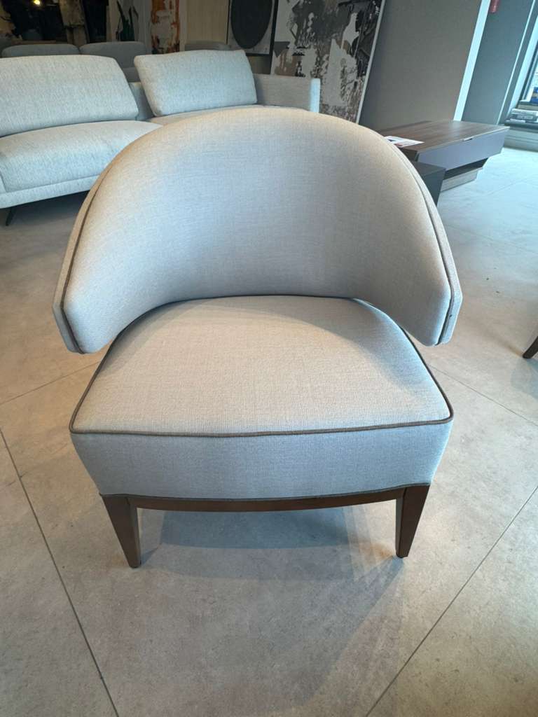 Beige armchair in a room with a couch and coffee table