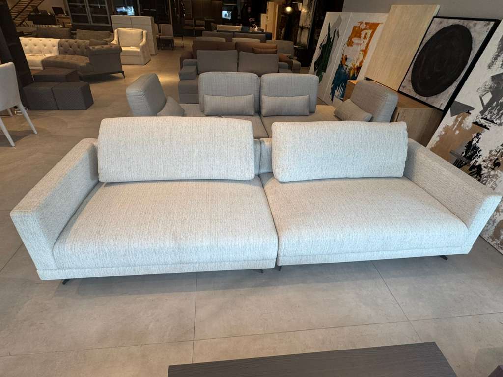 Light gray sofa in a showroom with other furniture and art in the background