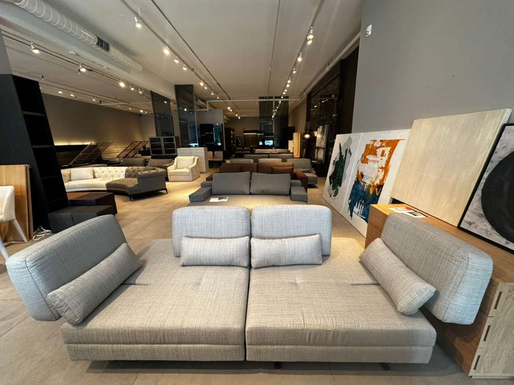 Modern living room with a large gray sectional sofa and various decor elements.