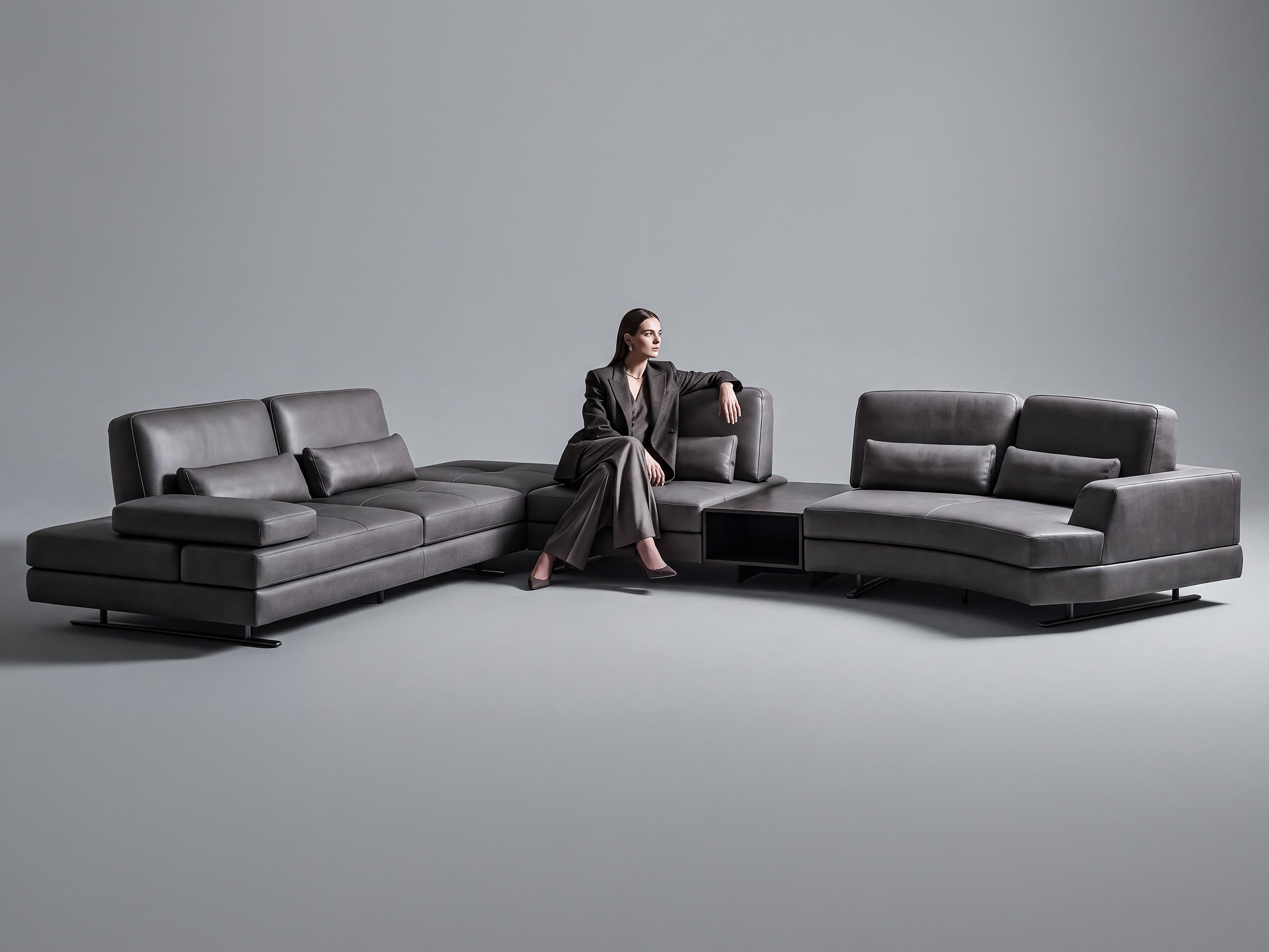 Mony sofa modern dark gray sectional sofa in a minimalist studio setting with a matching chaise lounge on both sides.
