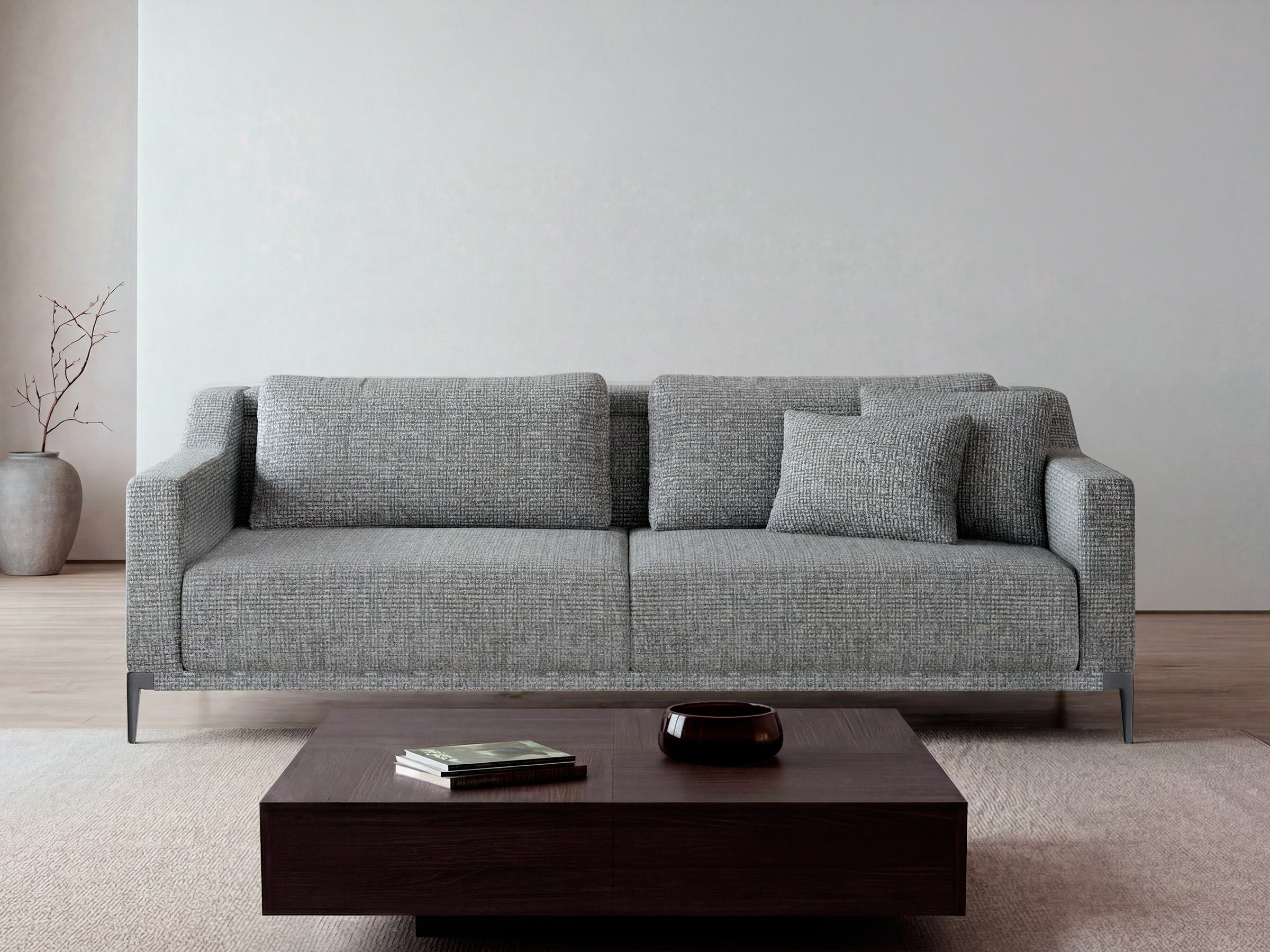 Gray sofa in a minimalistic living room with a wooden coffee table and decorative items.