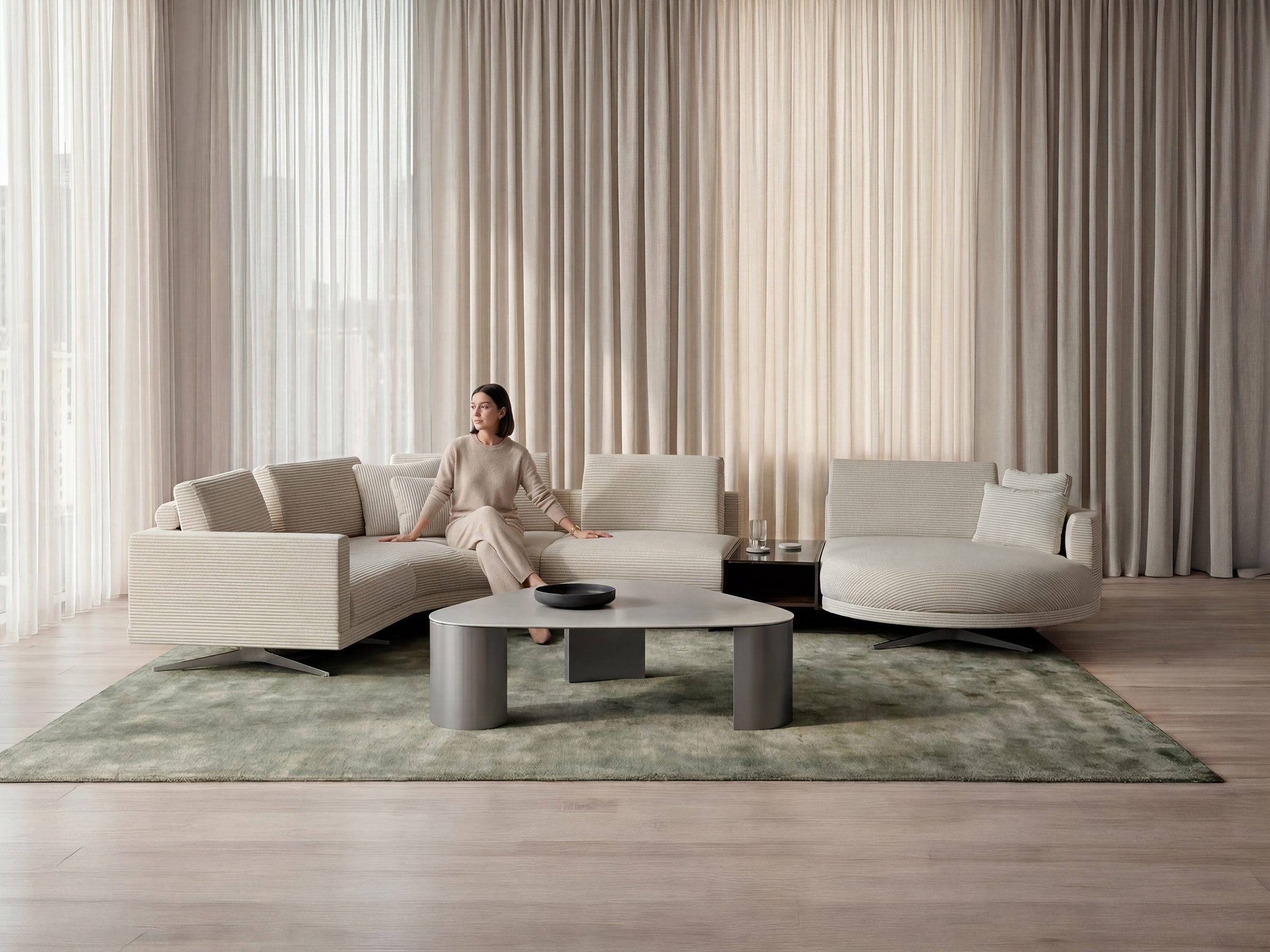 Woman sitting on a modern beige sofa in a stylish living room with large windows.