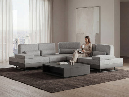 Woman sitting on a modern gray sectional mony sofa in a stylish living room.
