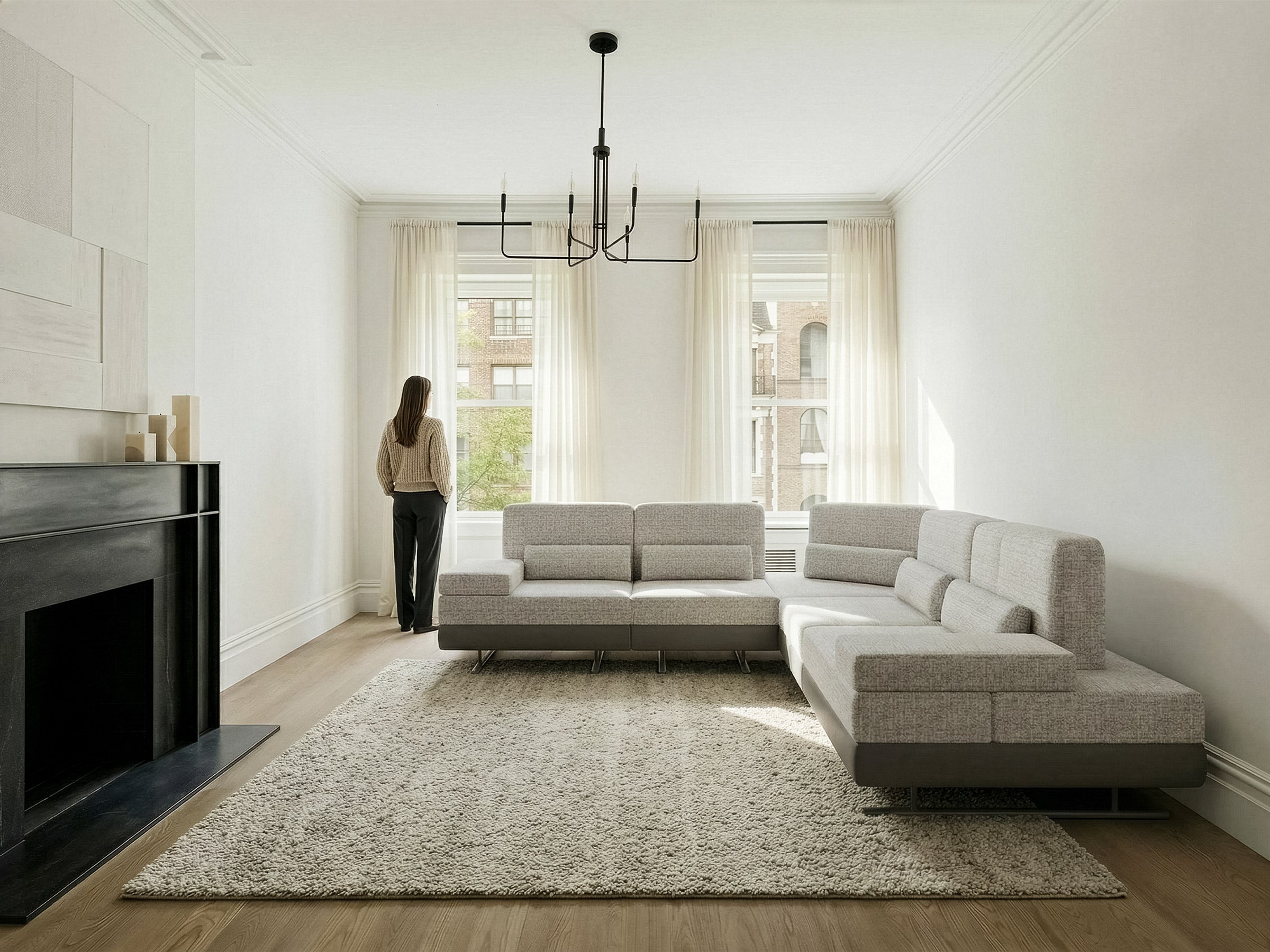 Modern living room with a sectional sofa, fireplace, and large windows.