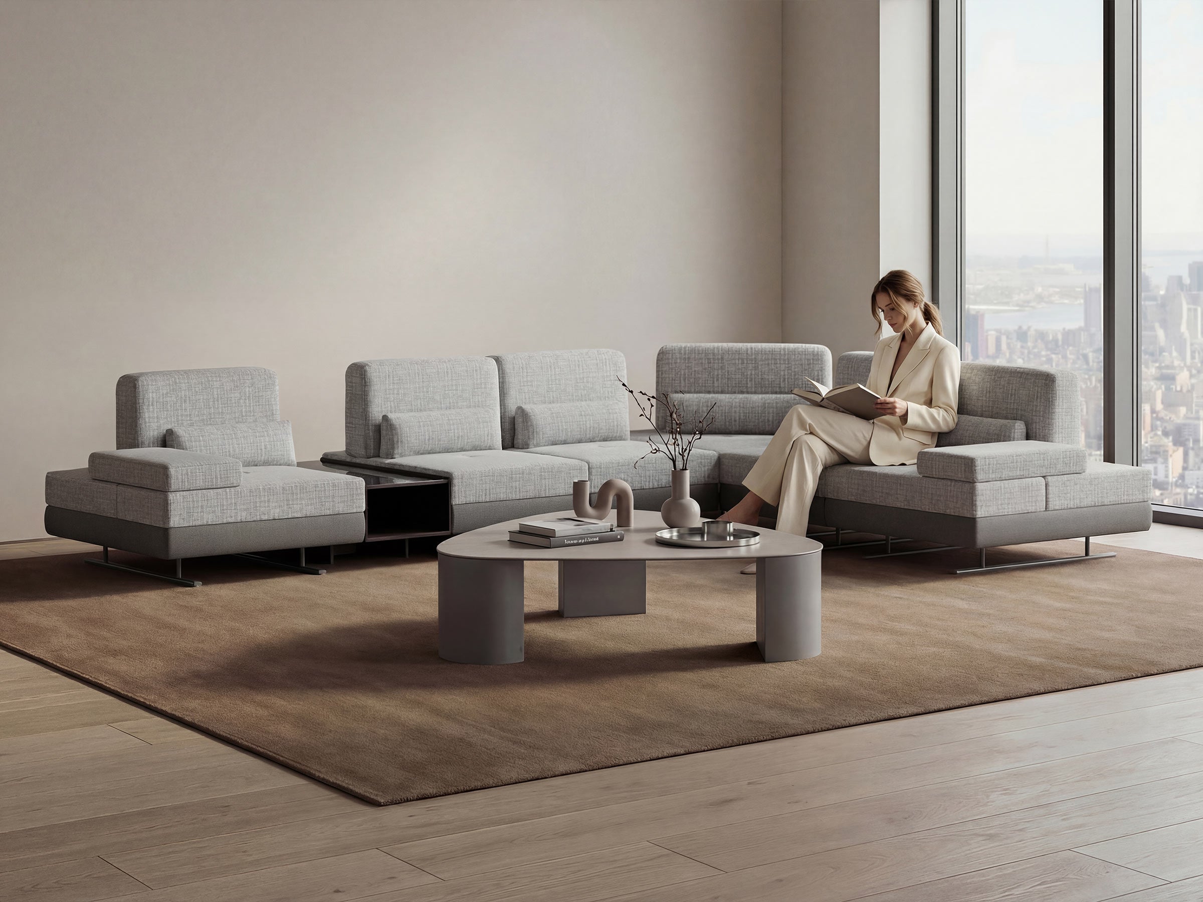 Modern living room with a gray sectional sofa and a woman reading a magazine.