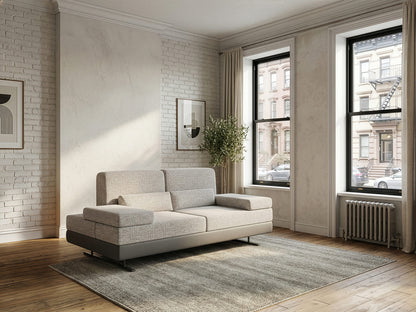 Modern living room with a gray sofa, large windows, and a brick wall.