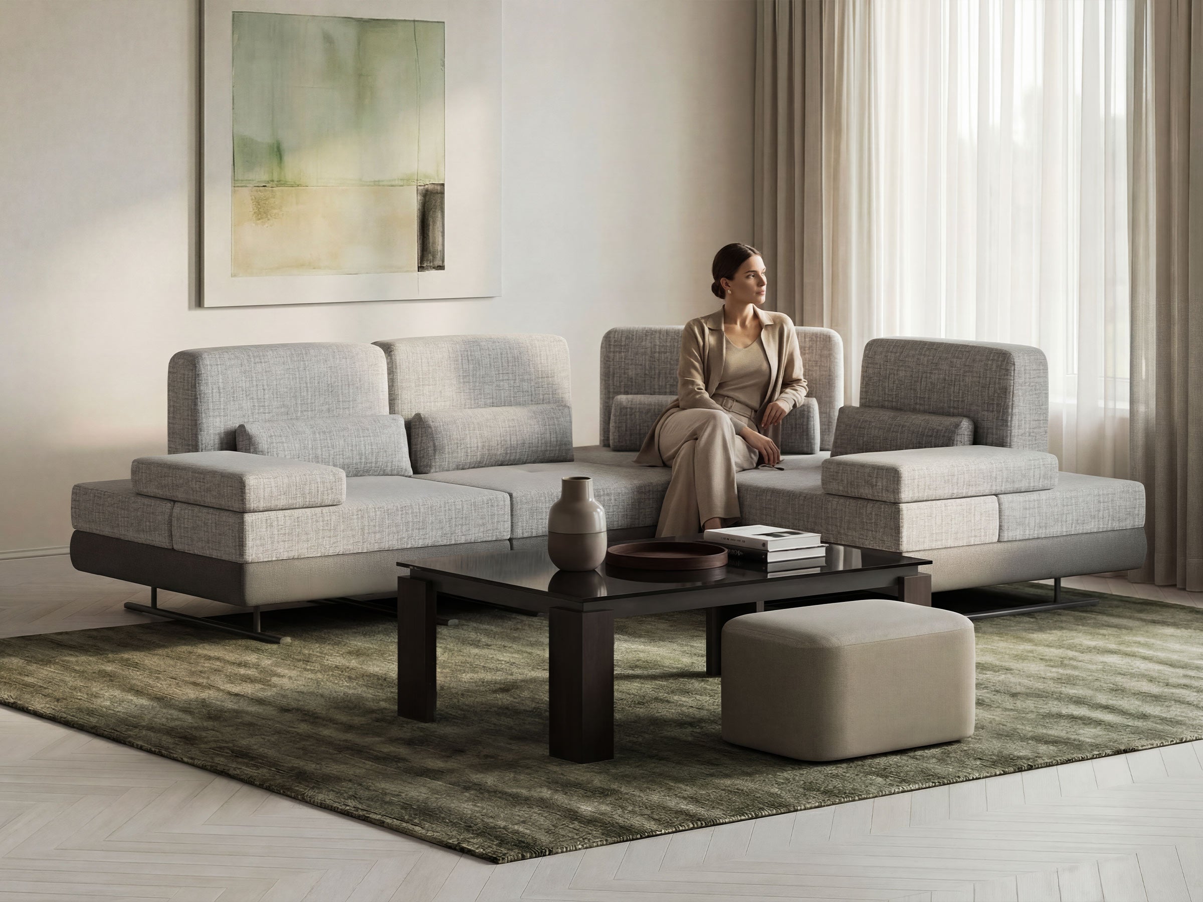 Woman sitting on a gray sectional sofa in a modern living room.
