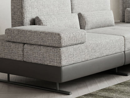Gray upholstered sectional sofa on a light wooden floor.