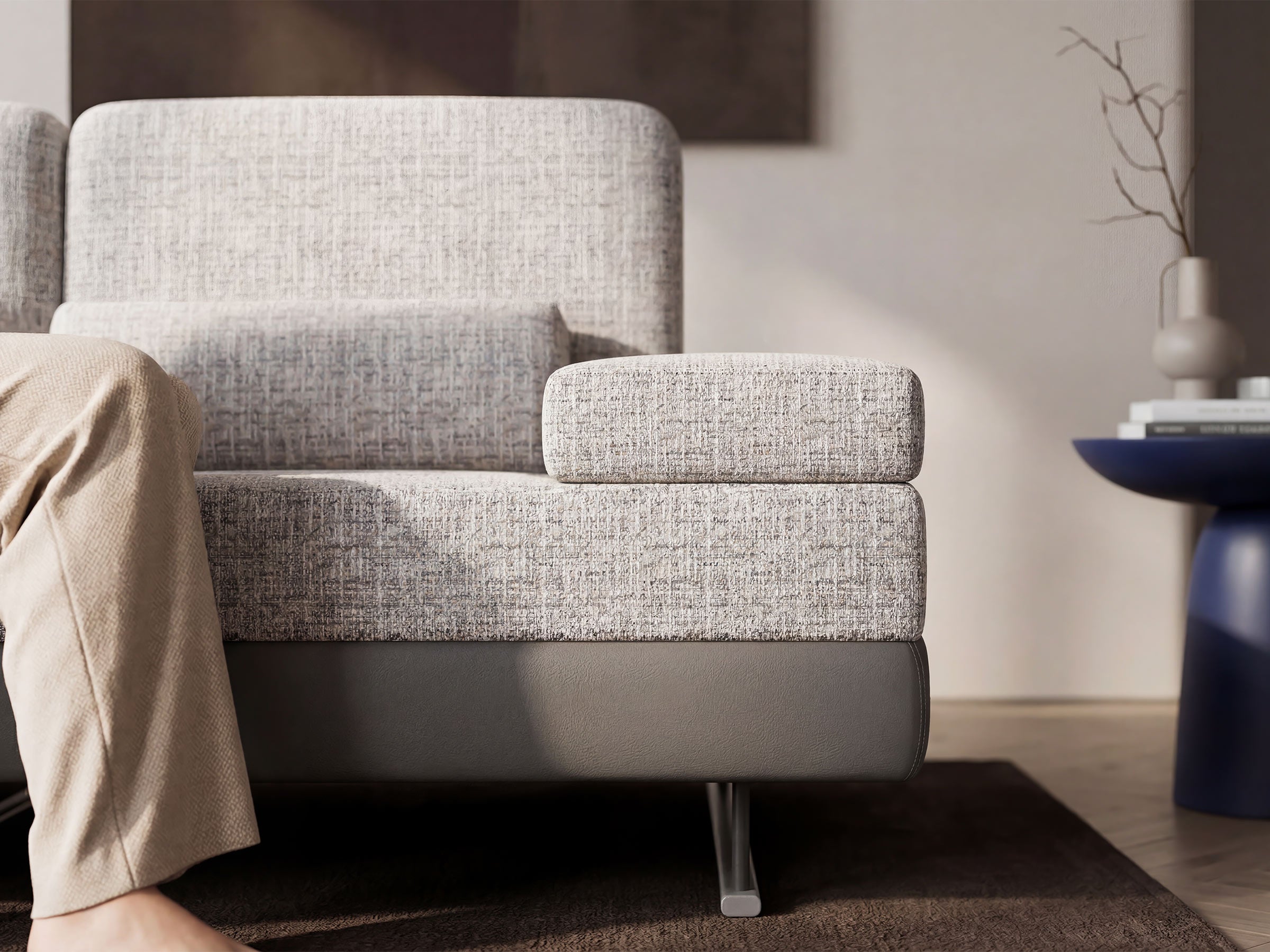 Gray armchair in a living room setting with a person sitting on it.