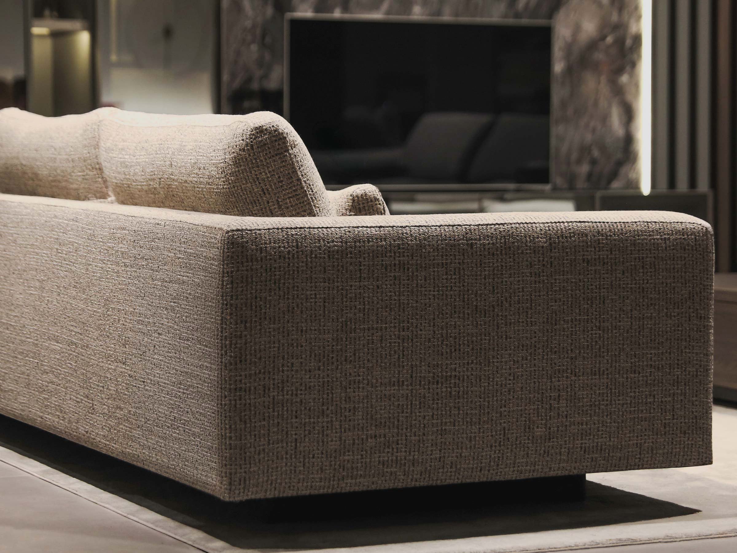 Merlin sofa in a living room setting with a television in the background.