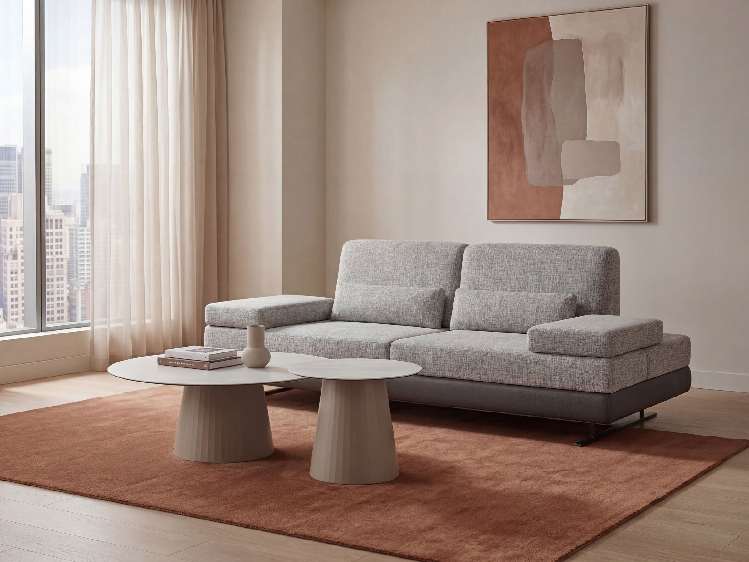 Modern living room with a gray sectional sofa, round coffee table, and abstract painting.
