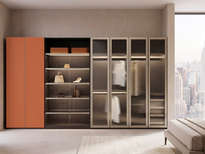 Modern wardrobe with orange doors and glass panels in a room with cityscape view
