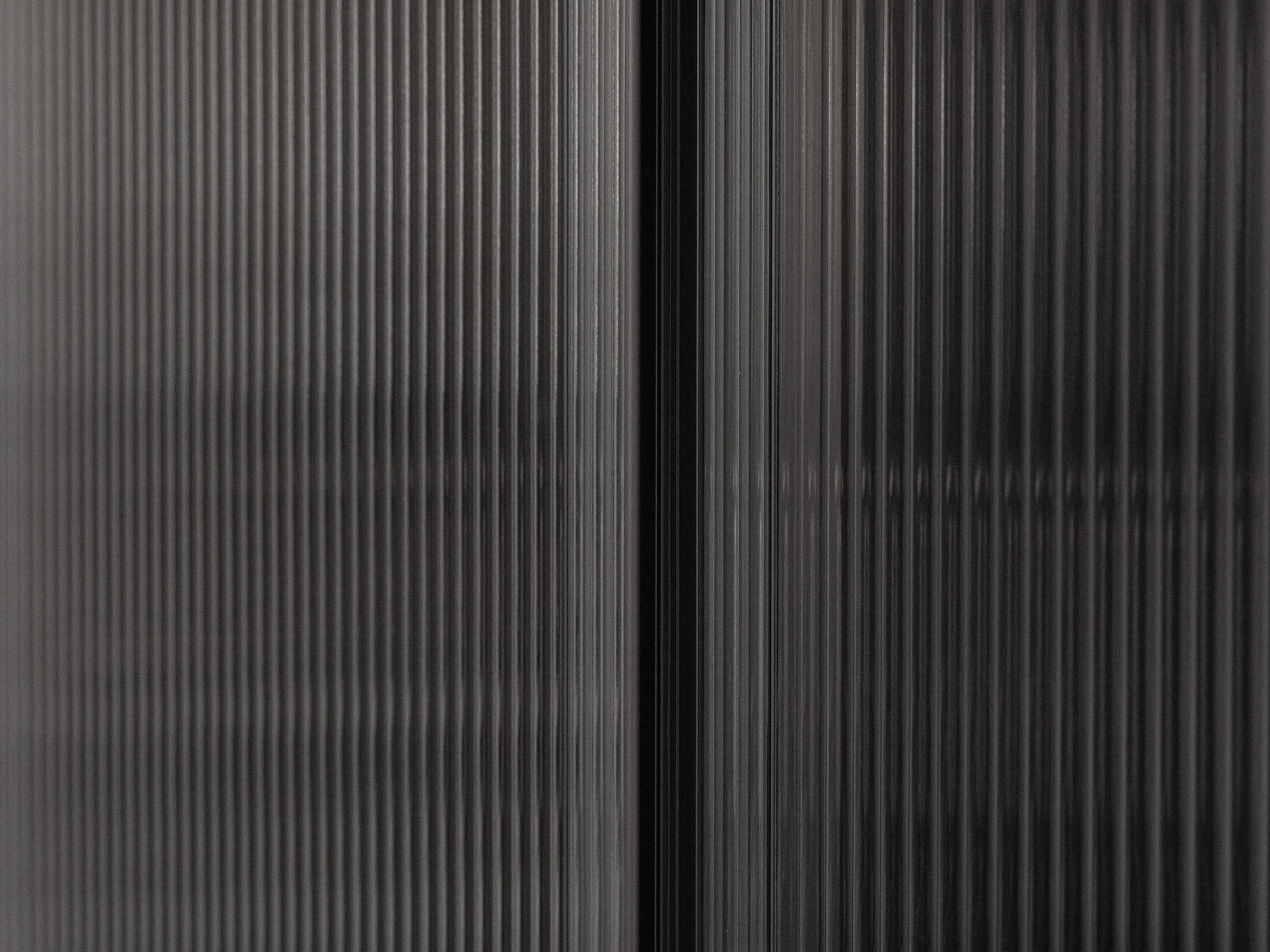 Close-up of a textured black surface with vertical lines