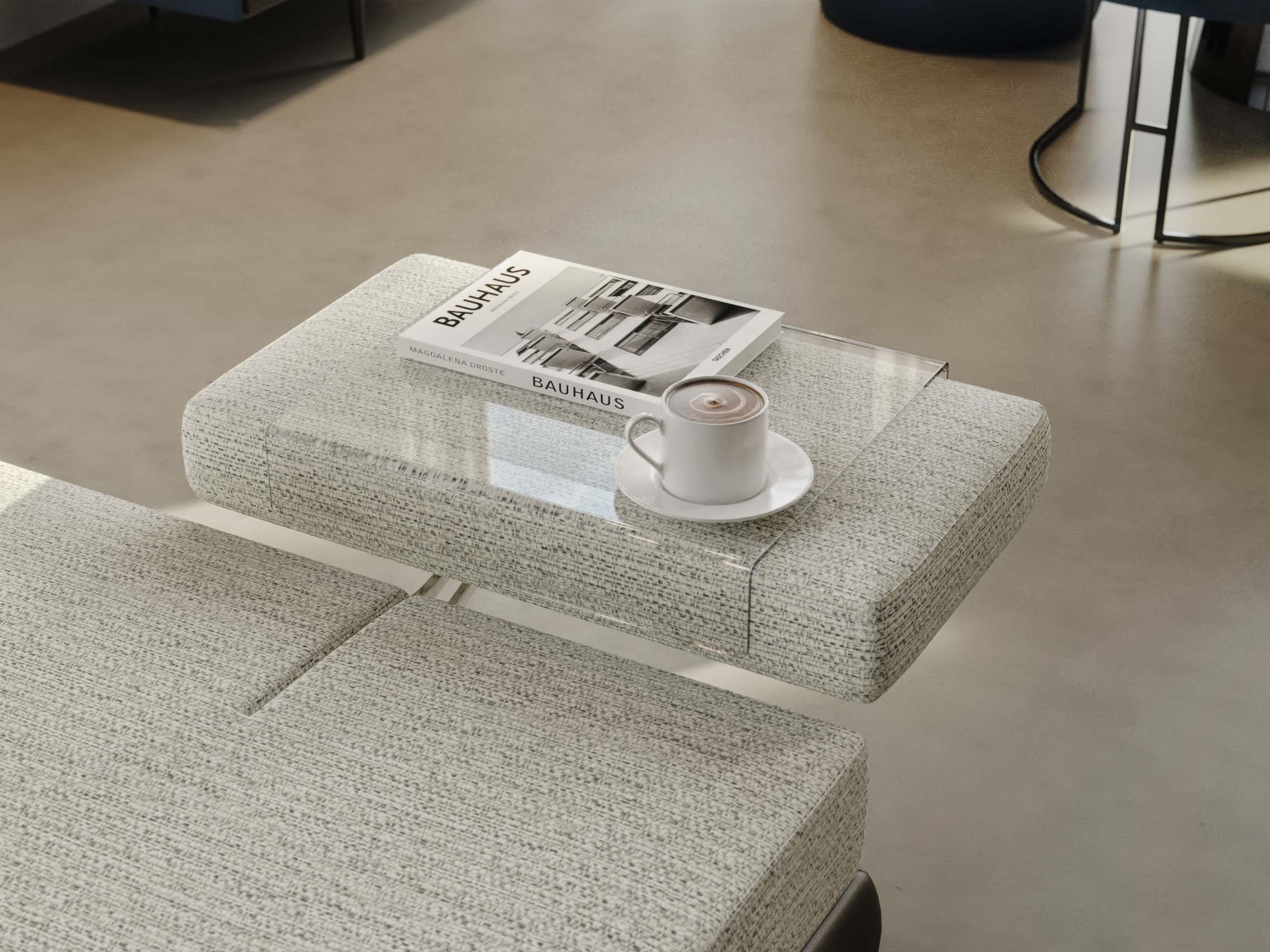 Textured ottoman with a magazine and coffee cup on a neutral floor.